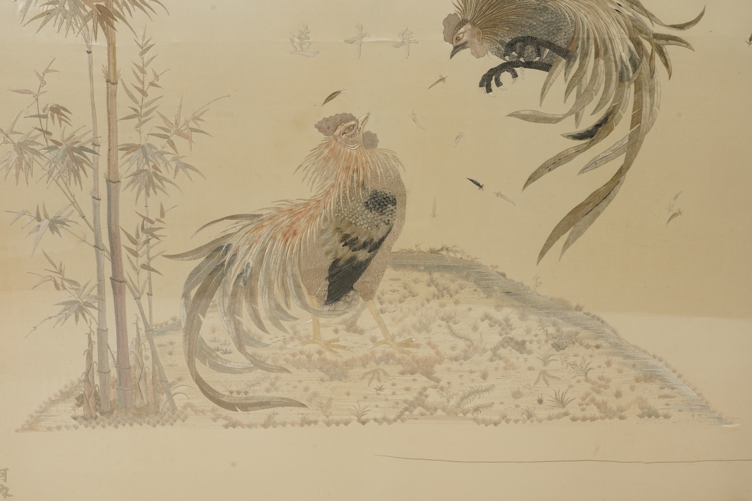 A large Japanese embroidered ‘fighting cockerels’ panel, Meiji period, signed Kawauchi, dated August 14, 1907
